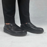 نمایی نزدیک از کفش طبی مردانه مدل کلارک، تماماً مشکی، ساخته شده از چرم طبیعی با جزئیات دوخت ظریف. طراحی ارگونومیک و کفی تخصصی برای حداکثر راحتی و حمایت قوس پا در استفاده روزانه طولانیمدت