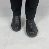 نمایی نزدیک از کفش طبی مردانه مدل کلارک، تماماً مشکی، ساخته شده از چرم طبیعی با جزئیات دوخت ظریف. طراحی ارگونومیک و کفی تخصصی برای حداکثر راحتی و حمایت قوس پا در استفاده روزانه طولانیمدت